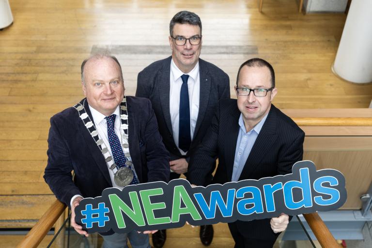 3 men holding sign for NEA Awards