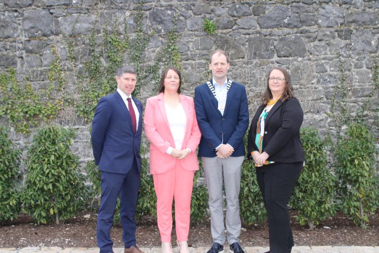 4 people standing in front of a wall