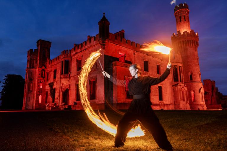 Man with circle of fire and old castle