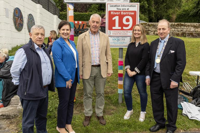 Group of people standing at sign with number 19