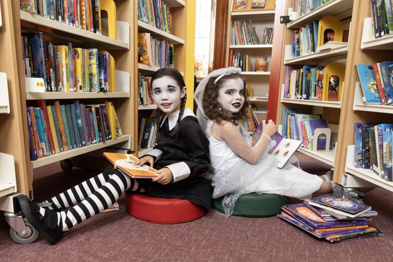 2 girls in spooky costume in library