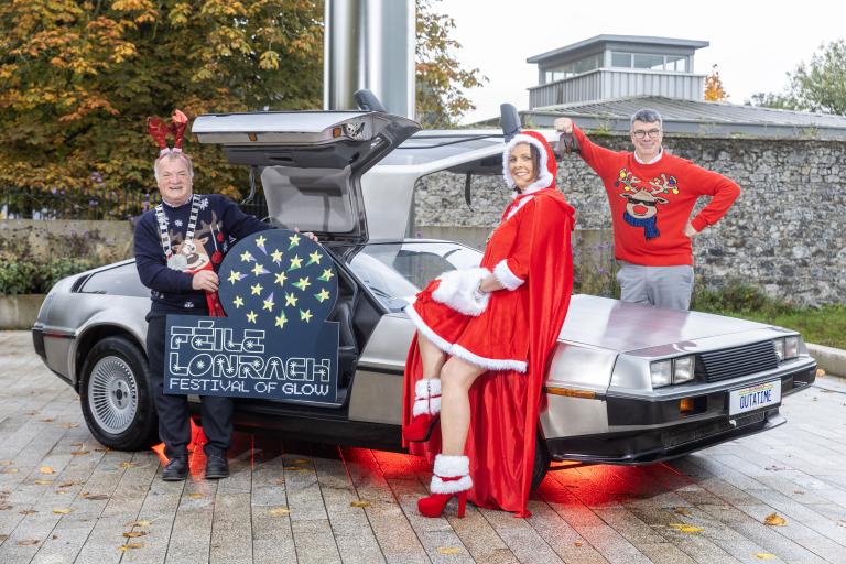 3 People in Christmas Costumes at old car