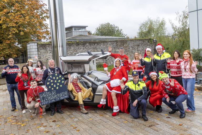 Group in christmas atire standing at old car