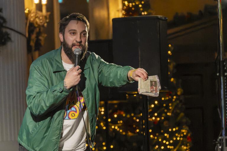 Man with green jacket on stage
