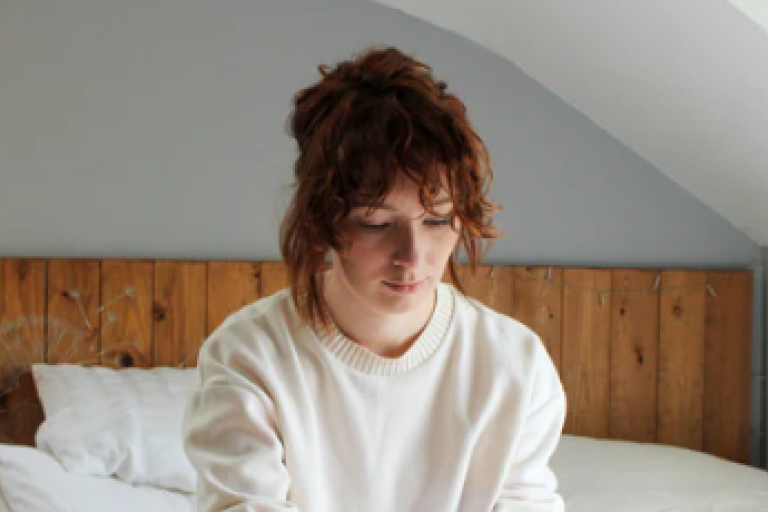 Person sitting on bed 