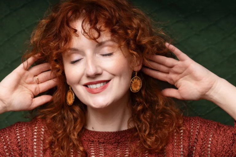 Woman with hands behind her ears