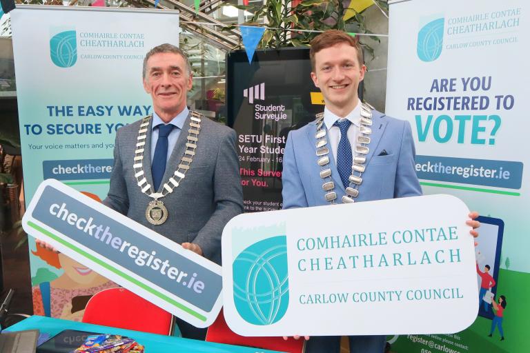 Two men in Chains holding a Sign