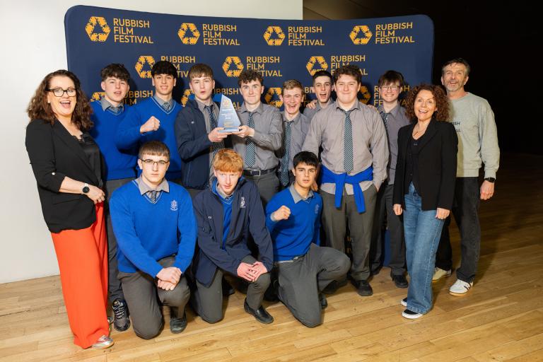 Group of students with teachers and holding trophy