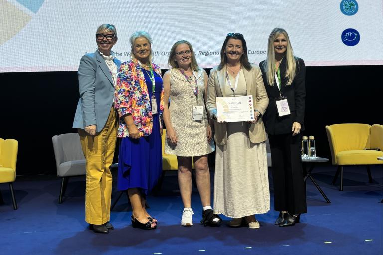 Group standing with certificate