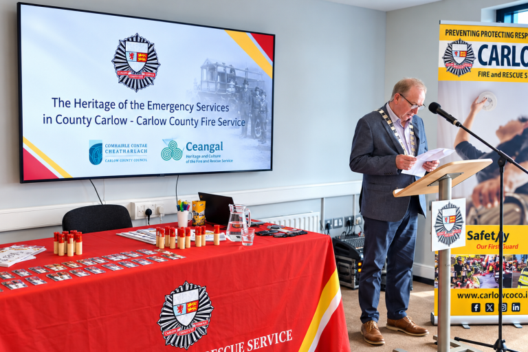 Man at podium with fire service posters