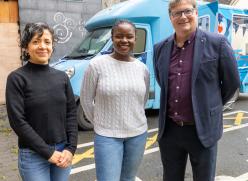 3 People standing in front of a blue van