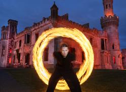 Man with ring of fire in front of old castle