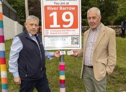 2 men standing at a sign with the number 19