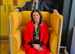 woman sitting in yellow chair and man standing behind chair