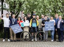 Group standing with bike and cyclist