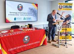Man at podium with fire service posters
