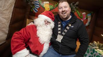 Santa with Smiling Man sitting on Lap