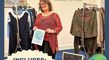 Woman standing with rails of clothes