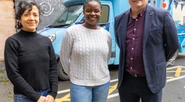 3 People standing in front of a blue van