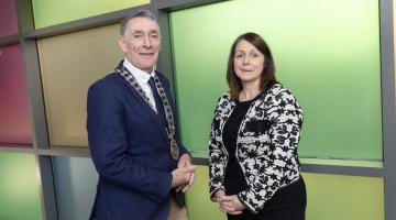 man with official chains and woman looking at the camera