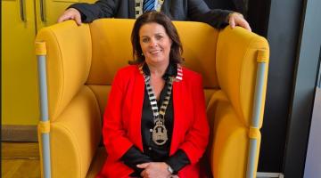 woman sitting in yellow chair and man standing behind chair