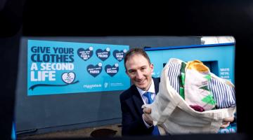Man holding bag of textiles