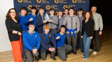Group of students with teachers and holding trophy