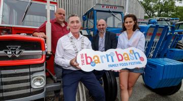 People sitting on tractor holding sign